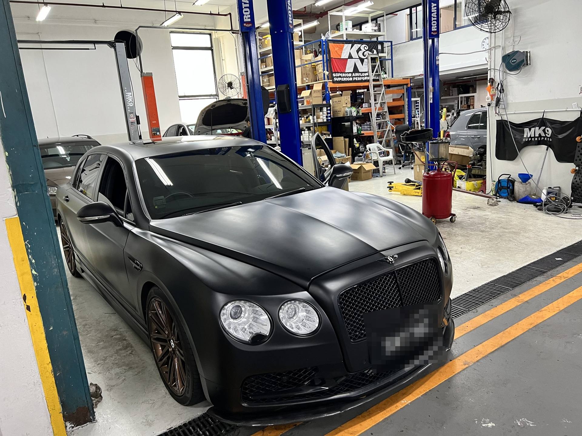 Matte black Bentley Flying Spur inside the MK9 workshop