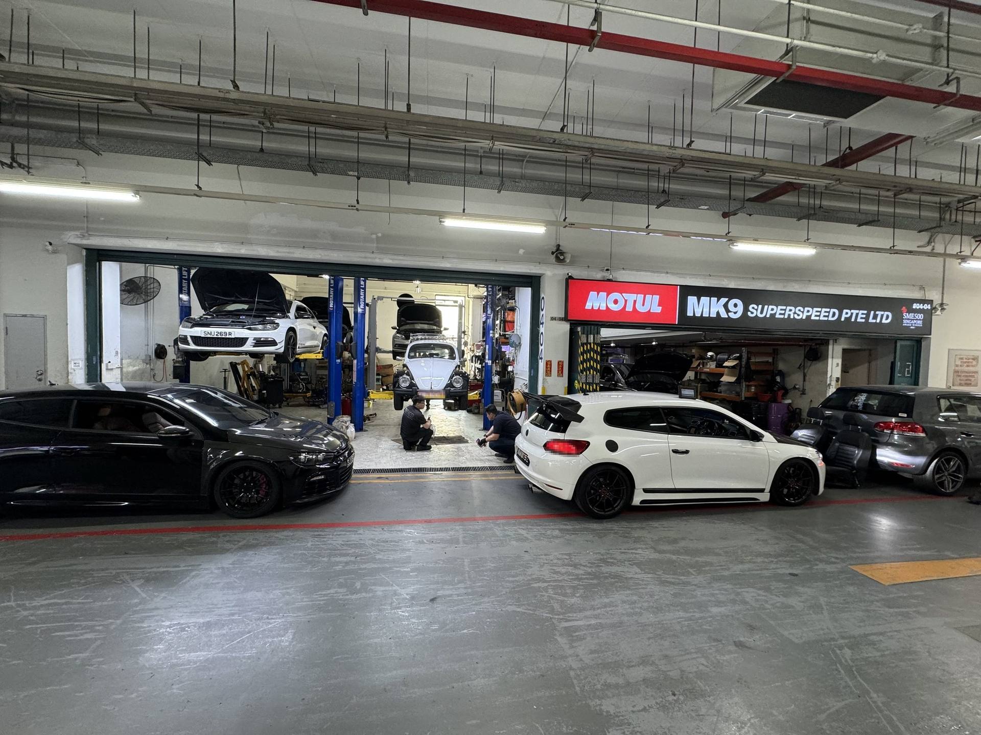 Wide view of the MK9 workshop with several cars